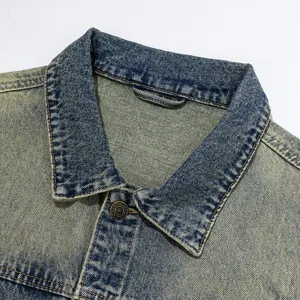 Vintage style denim jacket collar detail with distressed wash and metal button accents.