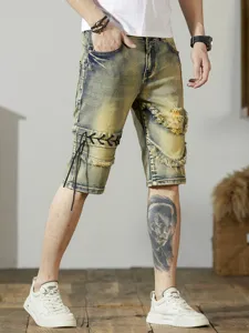 Primo piano di pantaloncini di jeans strappati da uomo con allacciatura laterale e lavaggio.