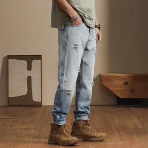 Detailed view of men's distressed gradient loose denim jeans, showing trendy casual style.