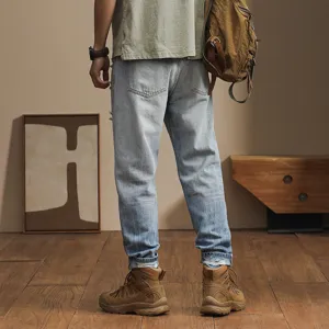 Mens casual light wash gradient denim jeans detailed back view showing loose tapered harem pants fit.