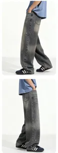 Detailed view of men's vintage washed baggy jeans with artistic paint splatter effect.