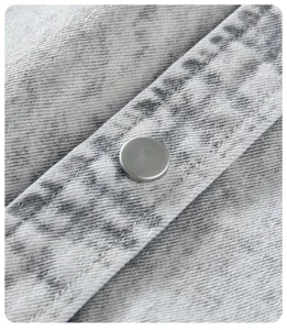 Primo piano di camicia giacca in denim vintage stile americano con bottone automatico e cuciture.