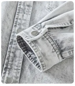 Vista dettagliata del polsino della camicia in denim e bottone a pressione vintage.