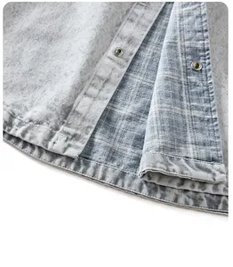 Vista di dettaglio di una giacca camicia in denim vintage americano con fodera a quadri e bottoni.