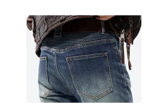 Detalle en primer plano de vaqueros de motorista para hombre con cintura plisada y denim lavado.