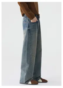 Vue détail des jeans homme vintage délavés bleu large droit avec panneaux structurés.