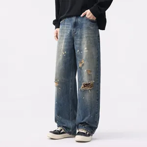 Men's vintage washed blue wide leg denim jeans with distressed details and cool style.