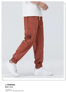 Summer casual loose Tencel cuffed long pants for men in rust red, comfortable straight trousers.