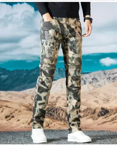 Detalle de vaqueros biker de camuflaje para hombre con parches rotos y rodillas plisadas.