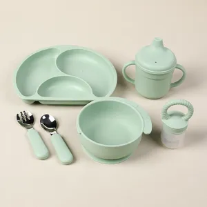Baby silicone feeding set with divided plate, sippy cup, spoon, bowl and feeder green details.