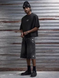 Détail short en jean homme avec strass, bords bruts style streetwear urbain été.