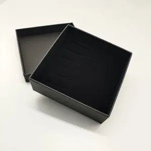 Vista detallada de caja de regalo negra con ranuras, ideal para pasadores de corbata y accesorios.
