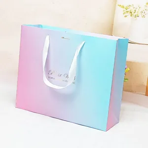 Gradient paper gift bag with white ribbon handles, ideal for business and wedding party gifts.