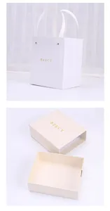 Vista detallada de caja de regalo blanca y bolsa de papel, embalaje minimalista para joyería.
