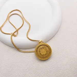 Detailed view of the vintage sand gold filigree hollow pendant necklace with snake chain.