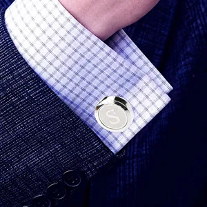 Detailed view of luxury men's French shirt metal cufflink with letter S design, classy accessory.