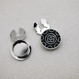 Metal round button with black floral pattern, vintage style clothing accessory for shirts.