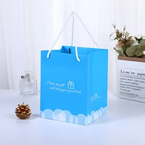 Bolsa de regalo de papel azul claro con asas blancas, ideal para cosméticos y compras.