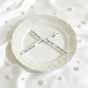 Nastro decorativo bianco a fiocco con testo stampato per confezioni regalo e decorazioni.