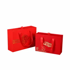 Red gold-stamped gift boxes for housewarming and longevity celebrations with ribbons.