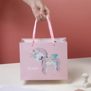 Pink unicorn gift paper bag with ribbon handles for kids party favors and candy packaging.