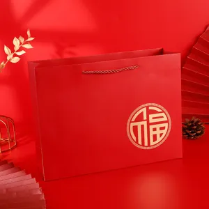 Red paper gift bag with gold blessing character design, perfect for wedding and celebration packaging.