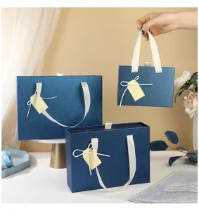Vue détaillée de boîtes cadeaux bleues en papier avec élégants rubans blancs et nœuds.