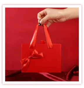 Detail de boite cadeau rouge avec ruban en satin, parfait pour petit emballage cosmetique chic.
