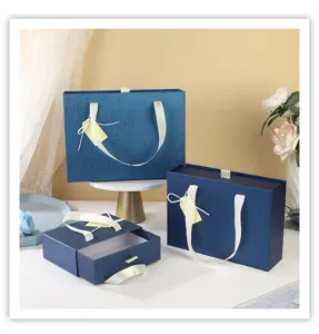 Détail de boîte cadeau tiroir bleue avec papier texturé de qualité et ruban blanc élégant.