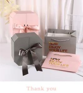 Creative pink and grey octagonal gift boxes with ribbon and matching gift bags for gifts.