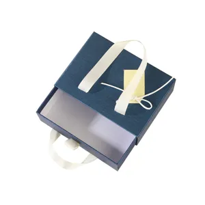 Boîte cadeau tiroir bleue avec ruban blanc, emballage élégant pour anniversaires et fêtes diverses.