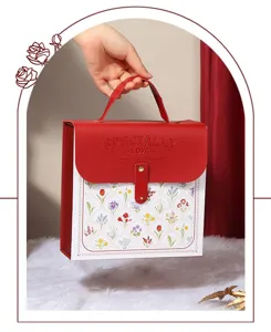 Red leather gift box detail with floral pattern and handle. Perfect for special occasions.