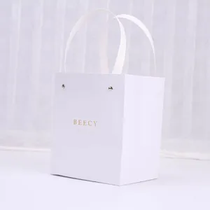 Bolsa de regalo de papel blanco minimalista con asas para joyería y empaque de lujo.
