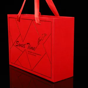 Scatola regalo per matrimonio rossa con nastro, elegante design geometrico dorato per feste.