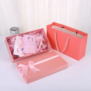 Pink bow gift box set with lid, shredded paper, greeting cards and matching paper bag packing.