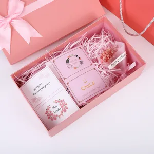 Pink gift box with bow and greeting cards, perfect for birthday and party packaging.