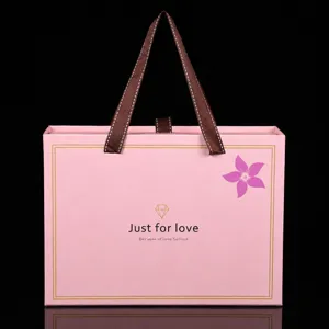 Scatola regalo rosa con manico in nastro e cassetto, ideale per bomboniere di nozze e feste.