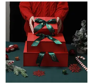 Detailed showcase of stacked red Christmas gift boxes adorned with elegant green ribbons.