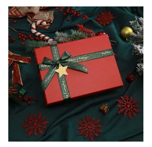 Red Christmas gift box with green ribbon and star pendant, festive holiday packaging detail.
