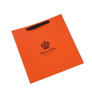 Orange paper gift bag with black ribbon handles and crown logo print for clothing stores
