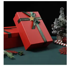 Red Christmas gift box with green ribbon and star detail, perfect for holiday candy and apple.