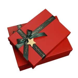 Red gift boxes set with green ribbon and star charm for Christmas and holiday packaging.