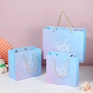 Gradient paper gift bags with rope handles, stylish tote bags for parties and holidays.