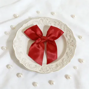 Dettaglio del fiocco in raso rosso, perfetto per decorare scatole regalo e feste.
