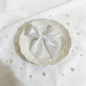 Primo piano dettagliato di un elegante fiocco in nastro di satin bianco sul piatto decorato.