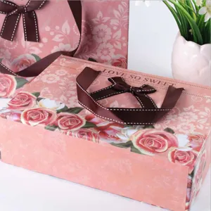 Pink rose gift box with brown ribbon, elegant packaging for wedding, birthday, and party favors.
