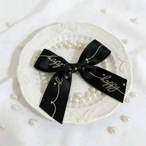 Fiocco in nastro di raso nero con stampa testo happy dettaglio per decorazione scatola.