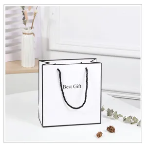White paper gift bag detail view showing elegant black border and handle design.