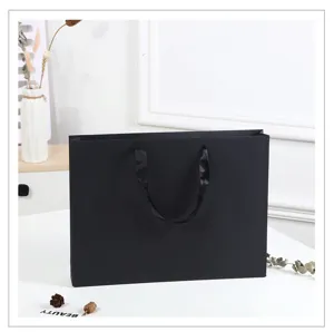 Detail view of large black cardstock gift bag with elegant black ribbon handles for business.