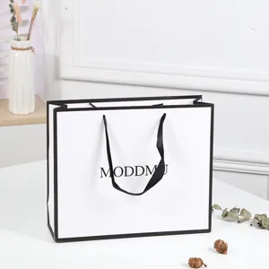White paper shopping gift bag with black handles and elegant minimalist design for clothing retail.